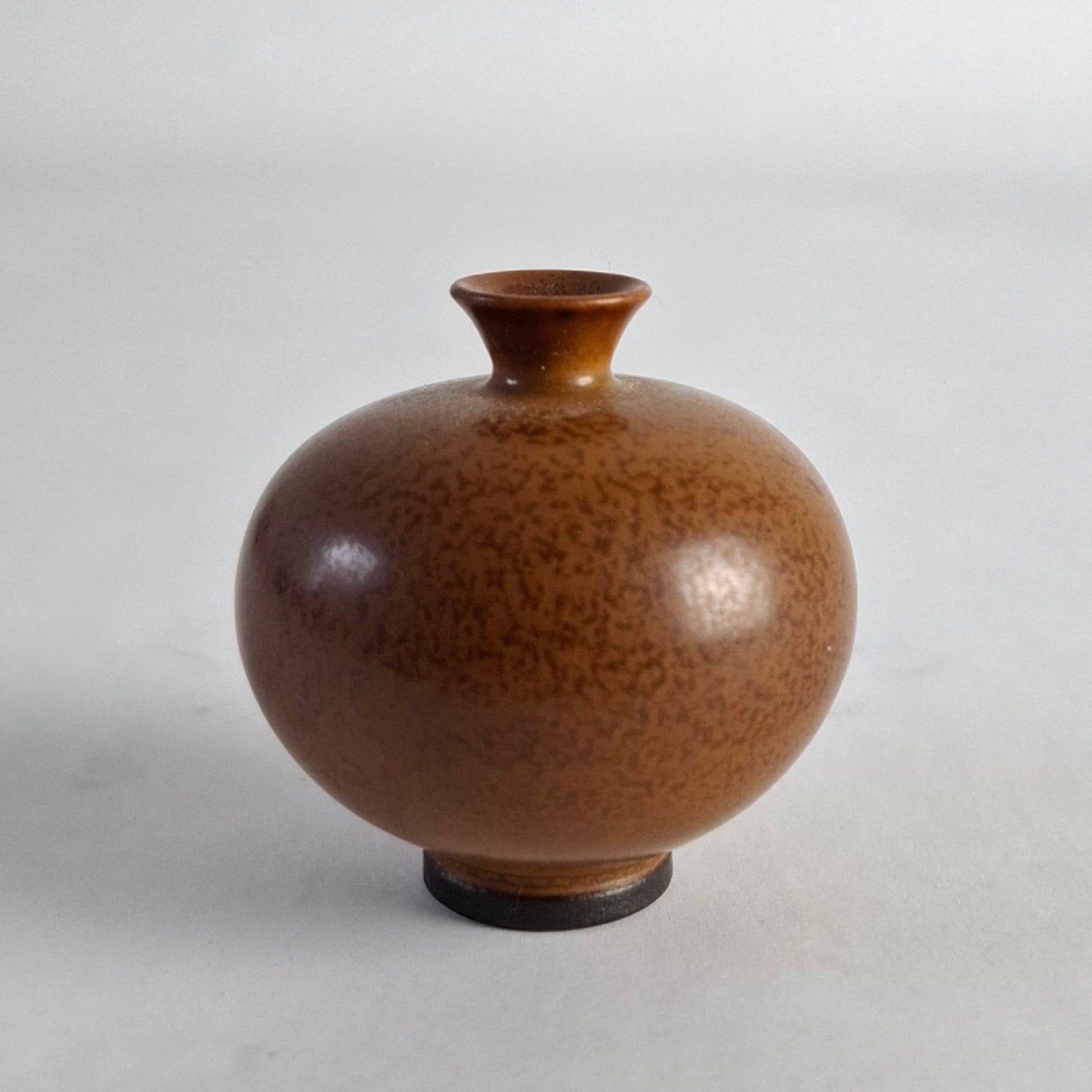 Miniature vase with a mottled brown glaze.