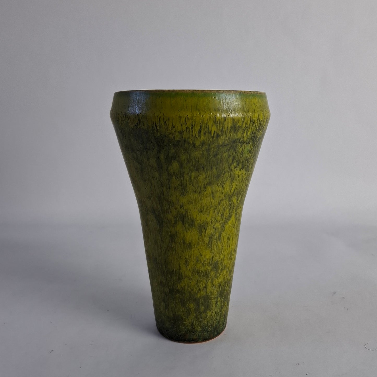 A cstoneware vase with a green solfatara glaze.