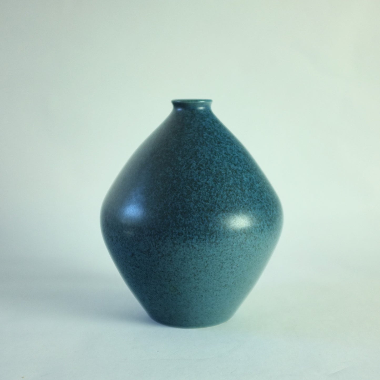 A stoneware vase with mottled blue glaze.