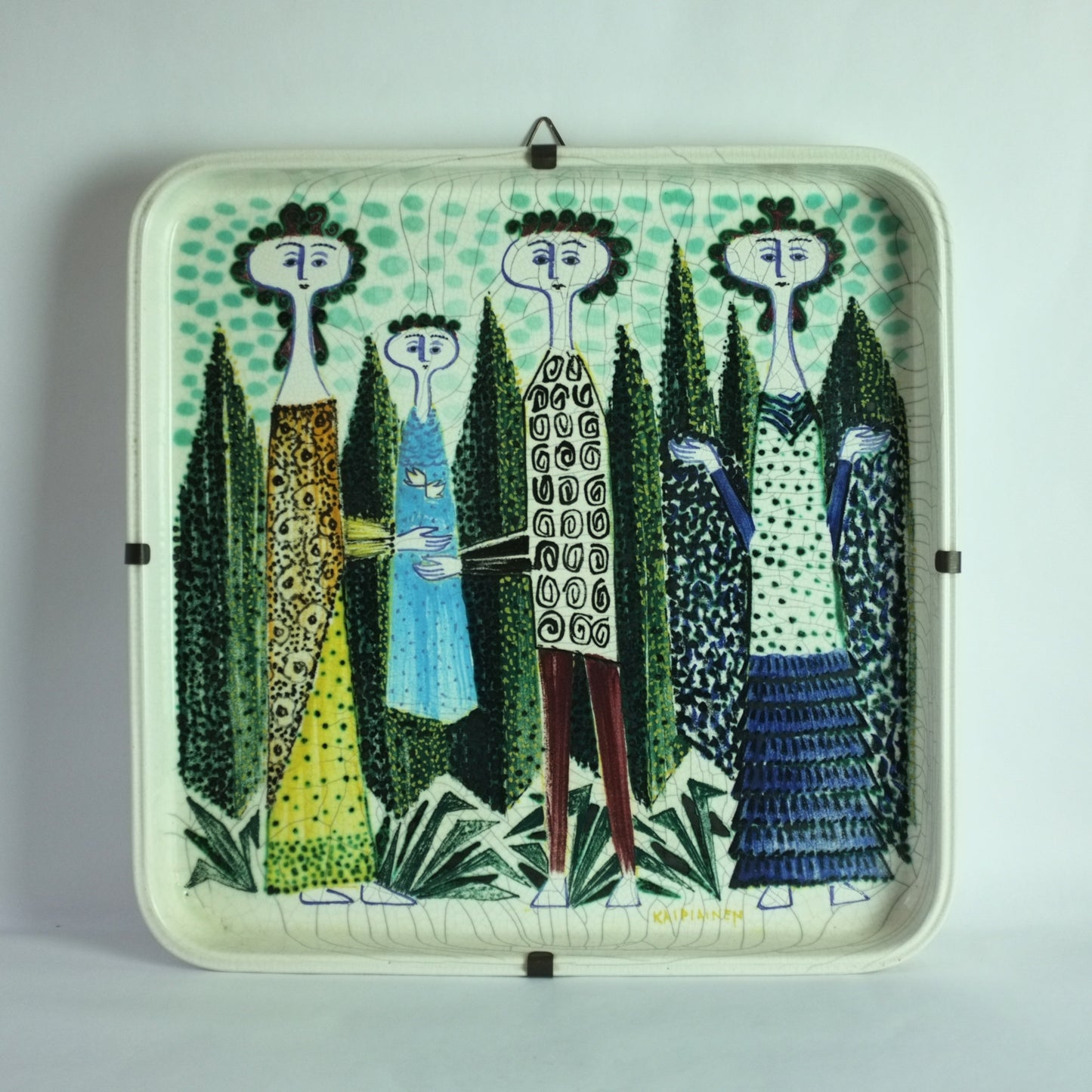 A square ceramic dish with a whimsical design of a family dressed in highly patterned clothing, standing amongst trees.