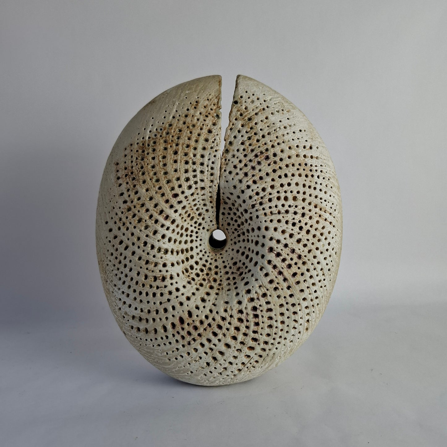 A stoneware vase of split form with spiralling incised decoration.background.