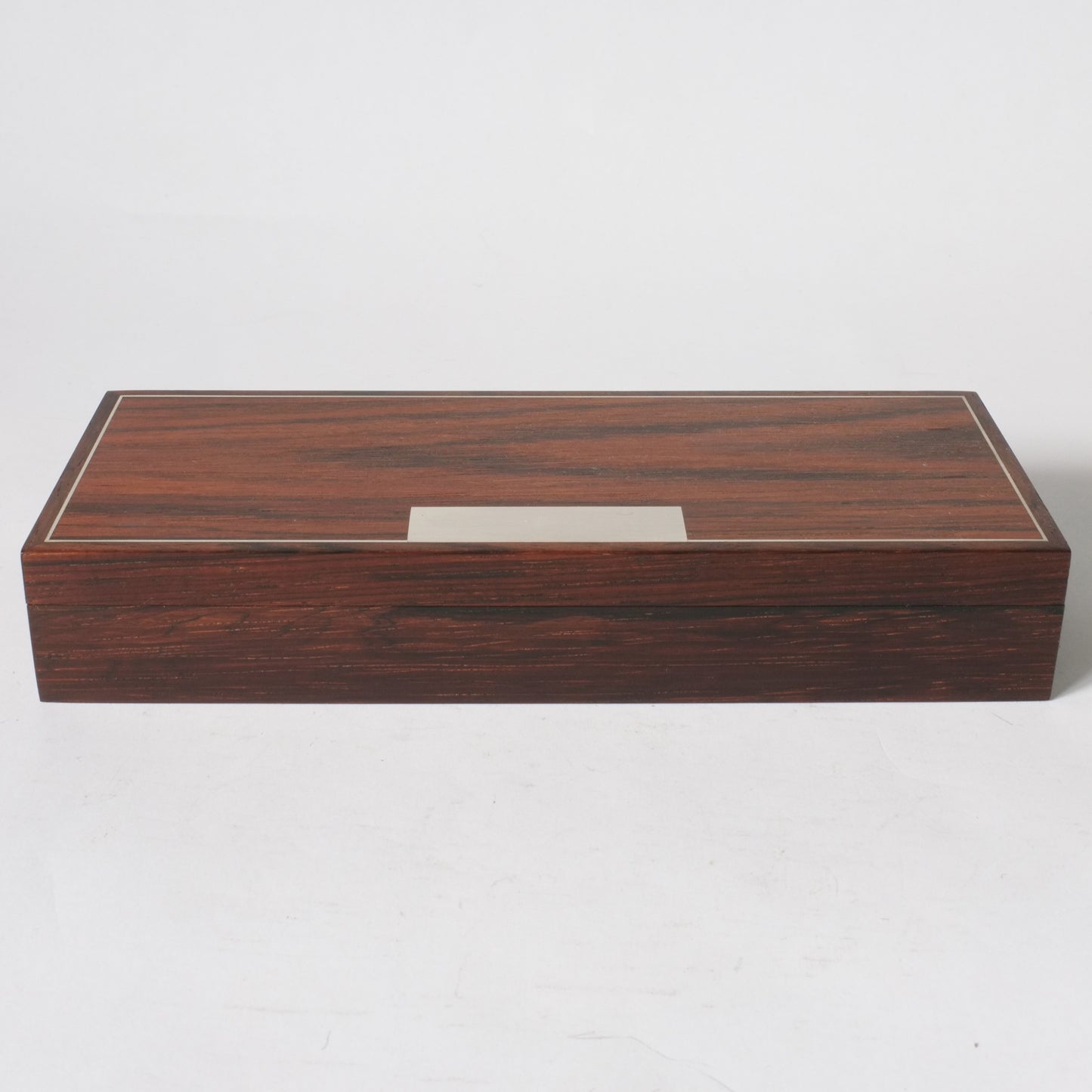 A rectangular rosewood box with silver inlay.