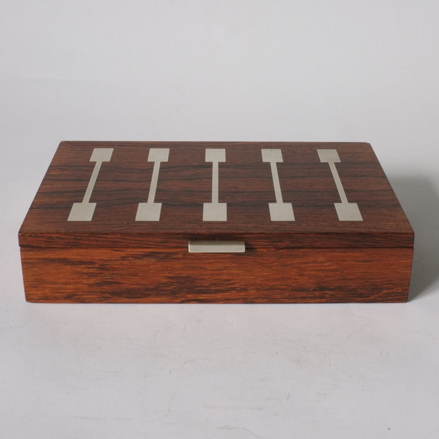 A rectangular rosewood box with silver inlay.