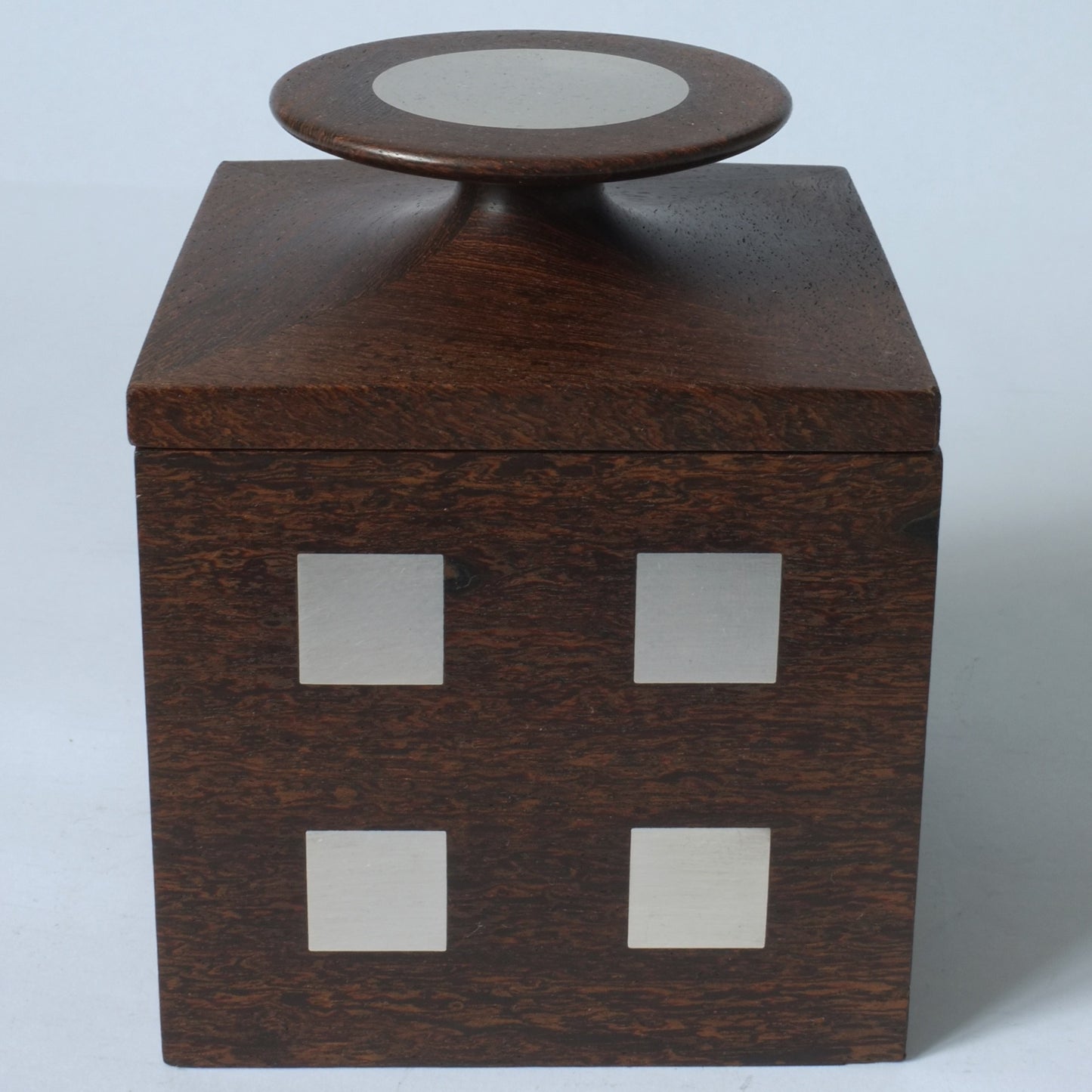 A wooden tea caddy with silver inlay.