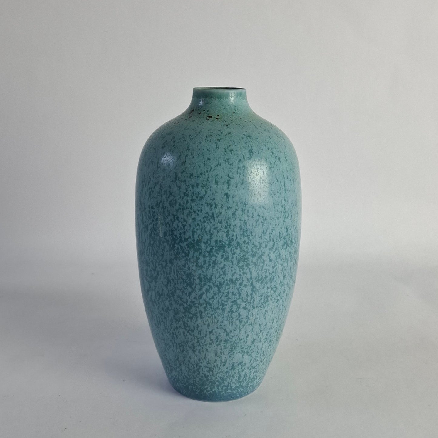 A stoneware vase with mottled blue and green glaze.