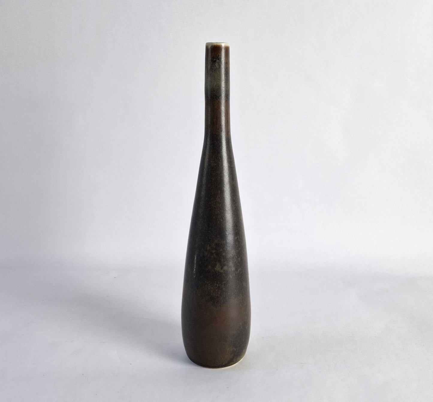 A stoneware vase with a mottled dark brown glaze.