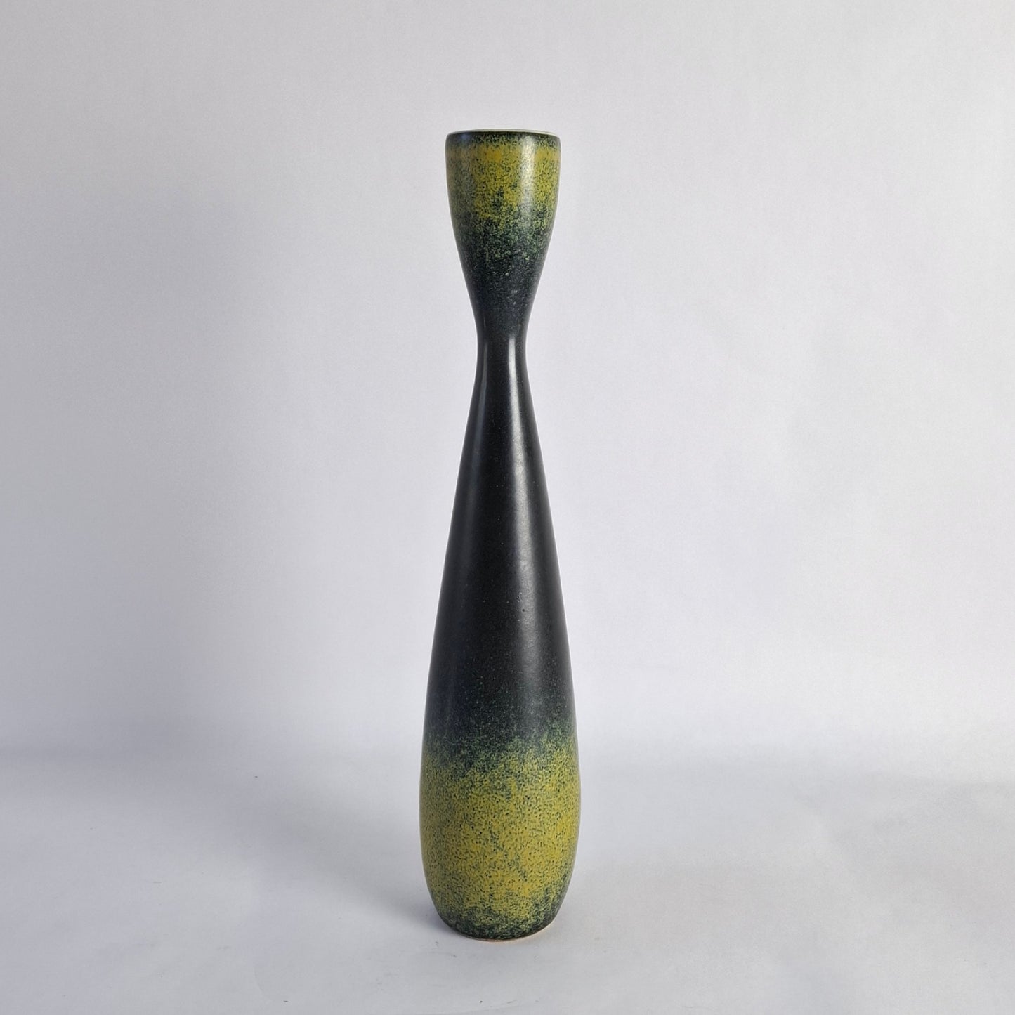 A tall stoneware vase with dark blue/grey and solfatara yellow glaze.