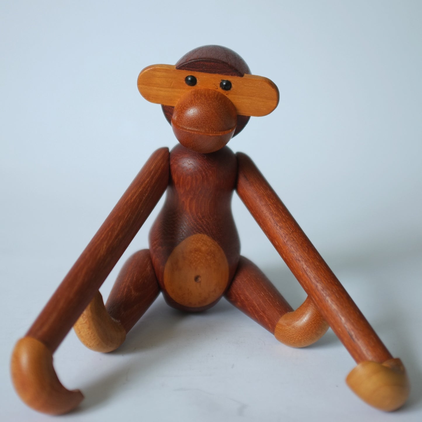 Wooden toy monkey with semi-articulated limbs.