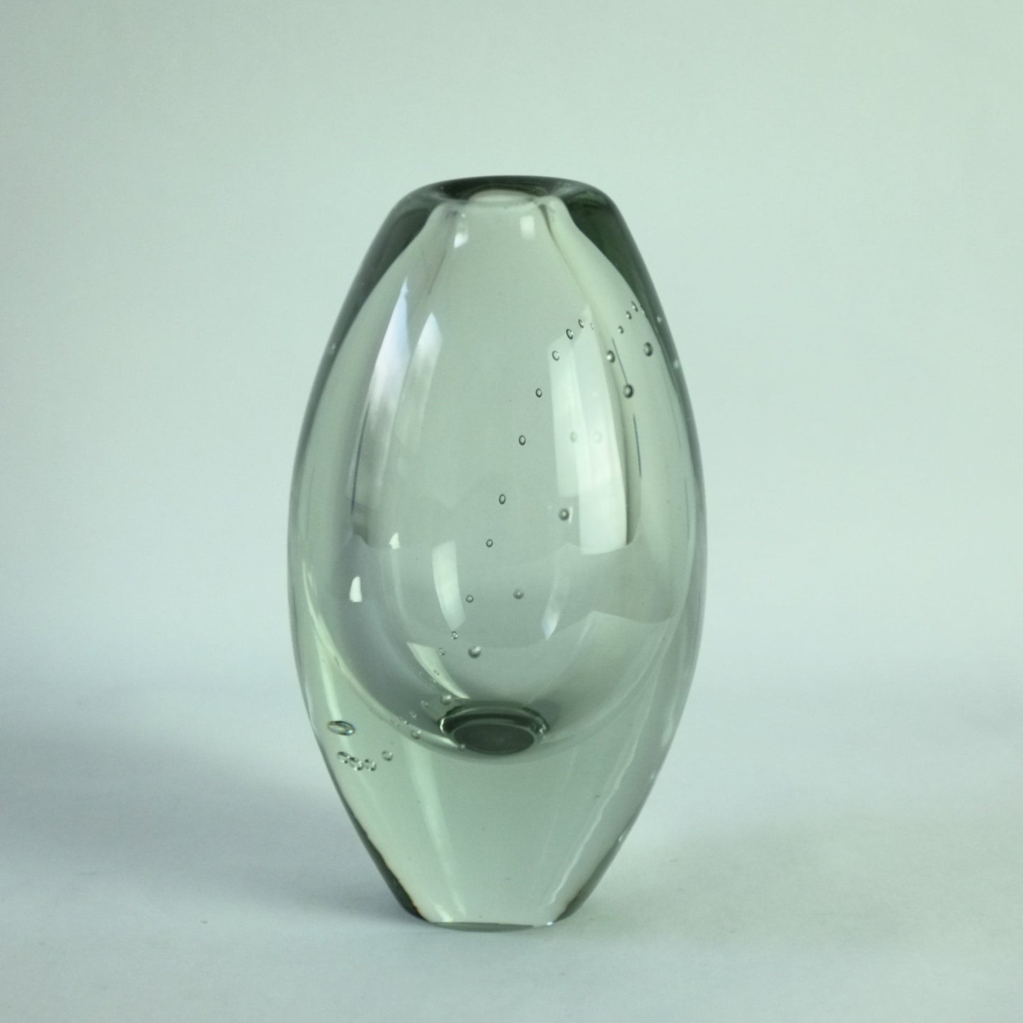 A clear glass vase with an internal line of air bubbles representing a pearl necklace design.
