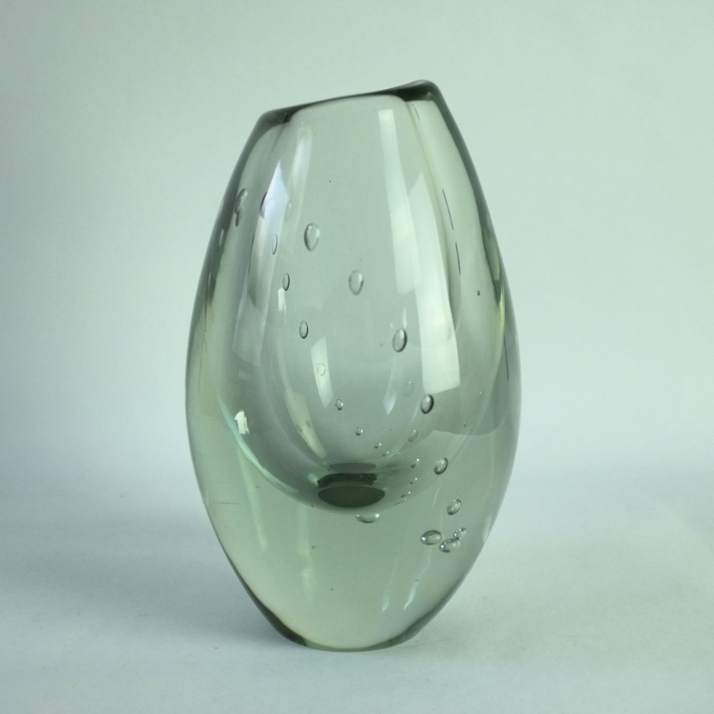 A clear glass vase with an internal line of air bubbles depicting a pearl necklace.