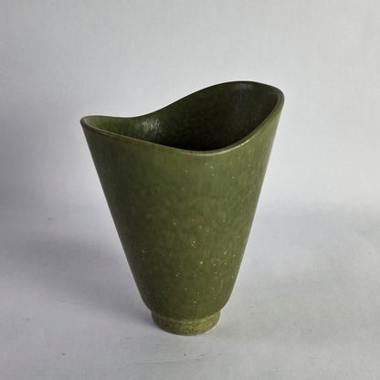 An asymmetrical stoneware vase with a green glaze.
