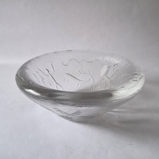 A clear glass bowl with wheel carved and acid etched cavemen hunting deer decoration.