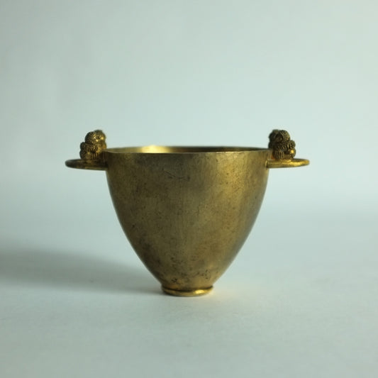 A hand hammered silver-gilt cup with with handles featuring small lions.