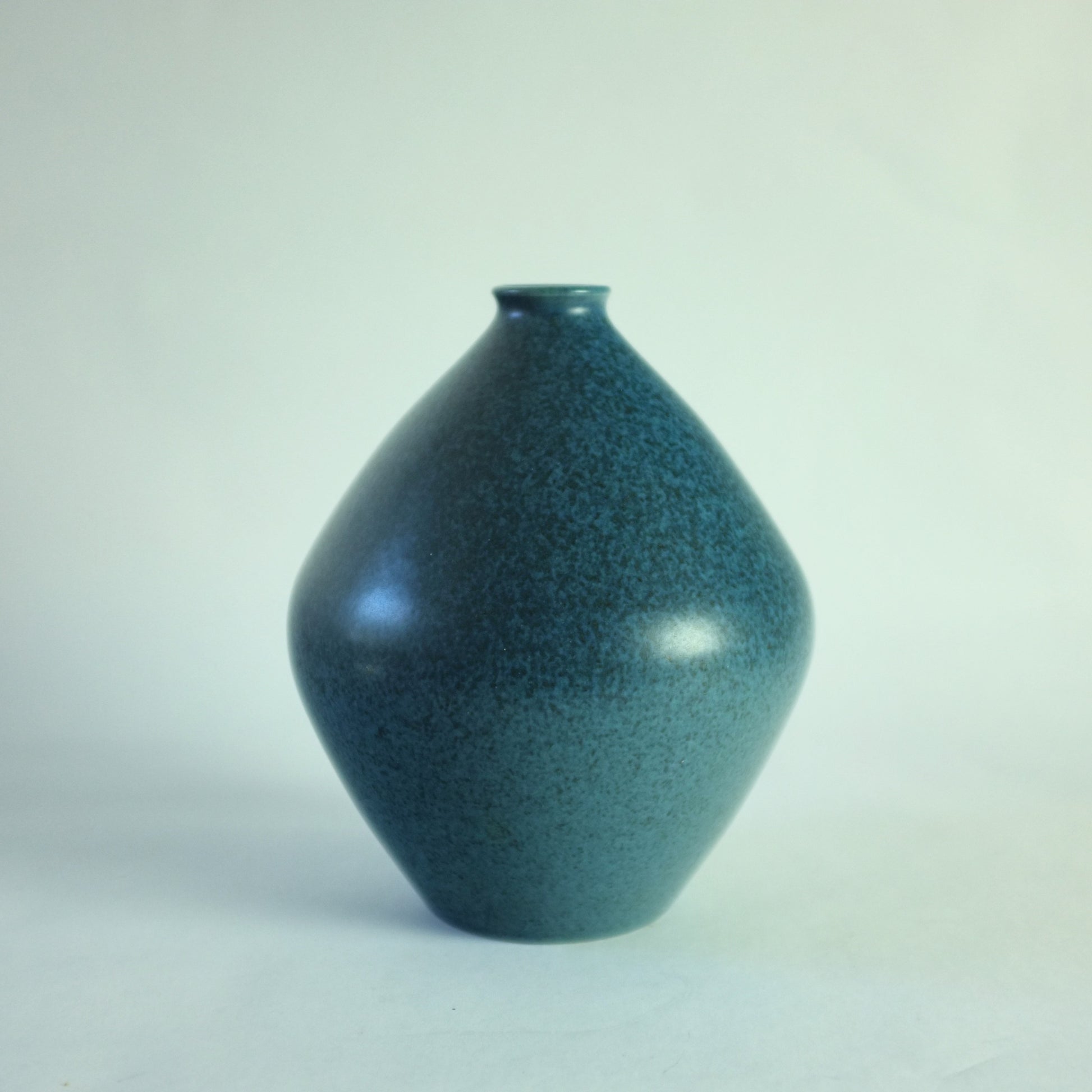 A stoneware vase with mottled blue glaze.