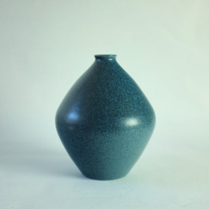 A stoneware vase with mottled blue glaze.