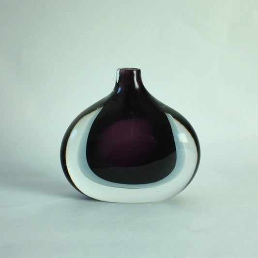 A double cased glass vase with deep purple, grey, and clear colors, free blown with a teardrop shape.