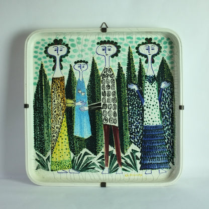 A square ceramic dish with a whimsical design of a family dressed in highly patterned clothing, standing amongst trees. 
