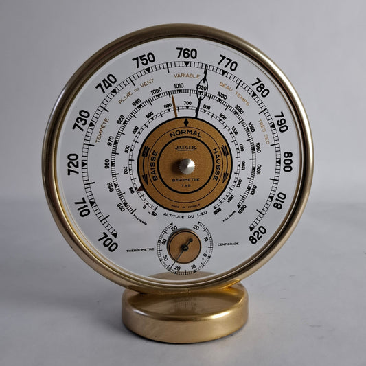 A vintage Jaeger barometer and thermometer weather station inglass and brass.