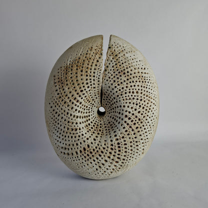 A stoneware vase of split form with spiralling incised decoration.background.