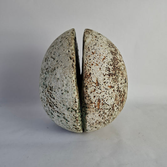 A large stoneware split sphere form with highly textured surface.