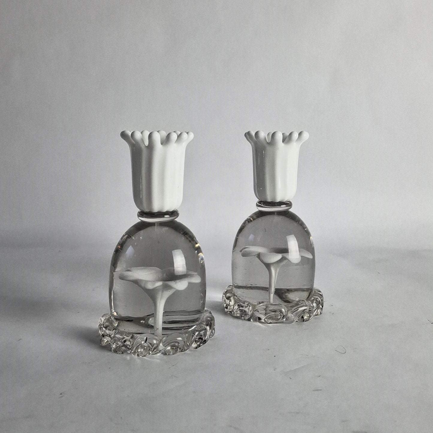 A pair of white and clear glass candlesticks with floral design, designed by Paolo Venini.