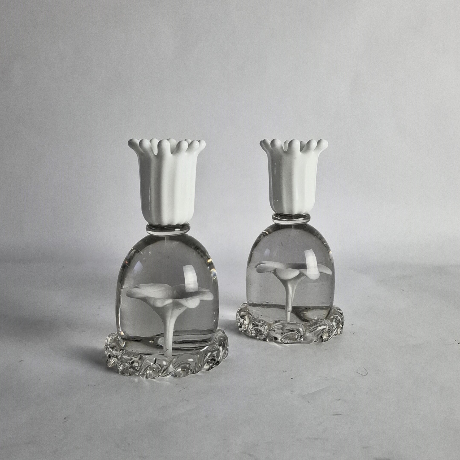 A pair of white and clear glass candlesticks with floral design, designed by Paolo Venini.