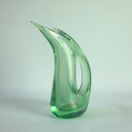 A light green, abstractly shaped glass vase with an iridized surface.