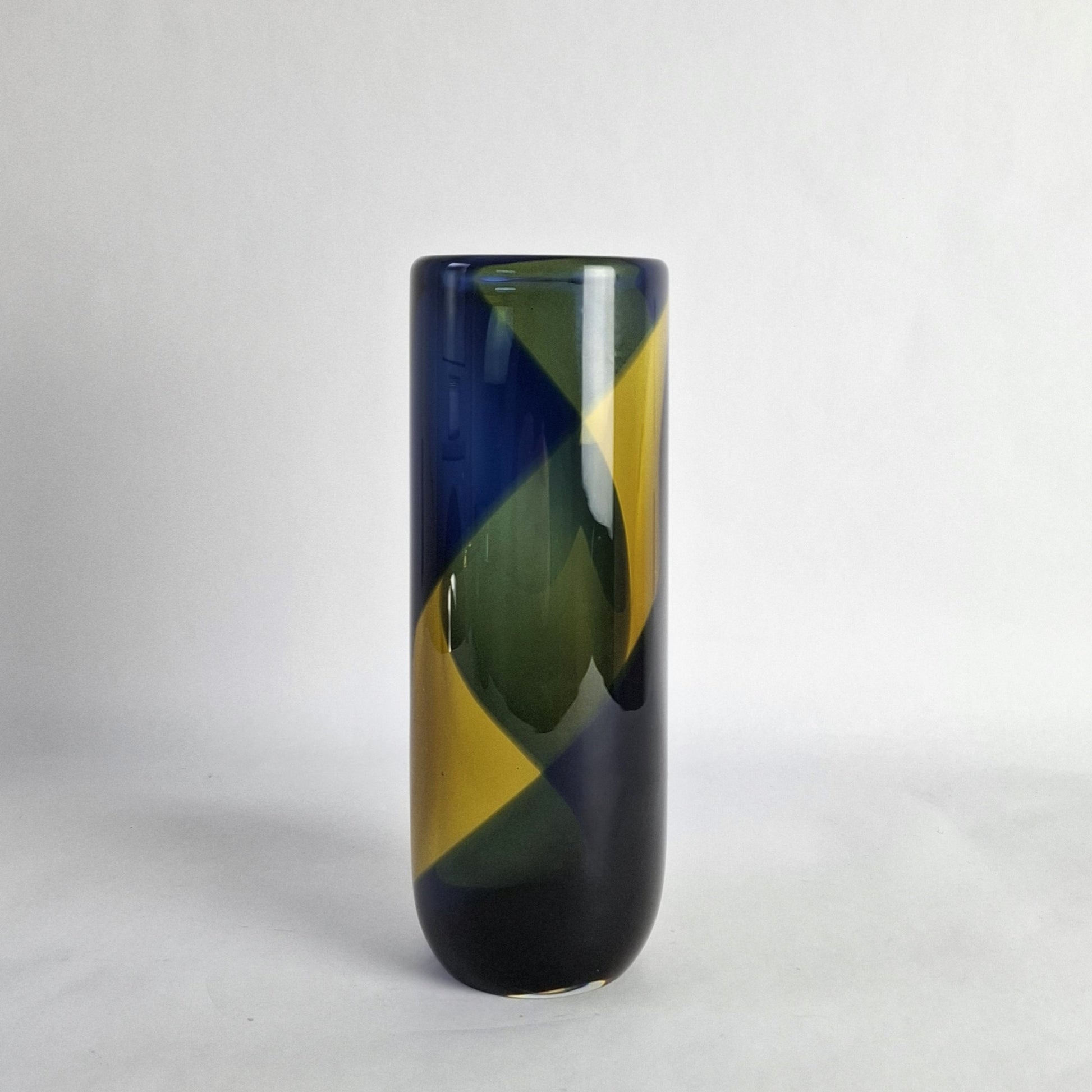A cylindrical glass vase with a wide banded spiral design in blue and yellow.