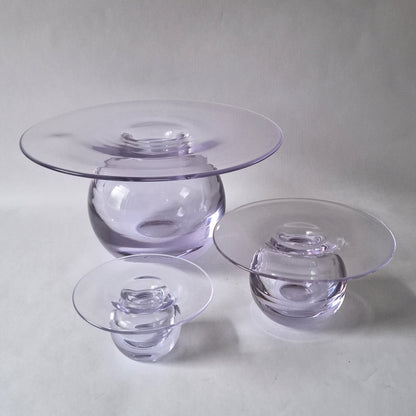 A set of three graduated clear glass vases with a wide flat rim above a spherical body, designed by Nanny Still.