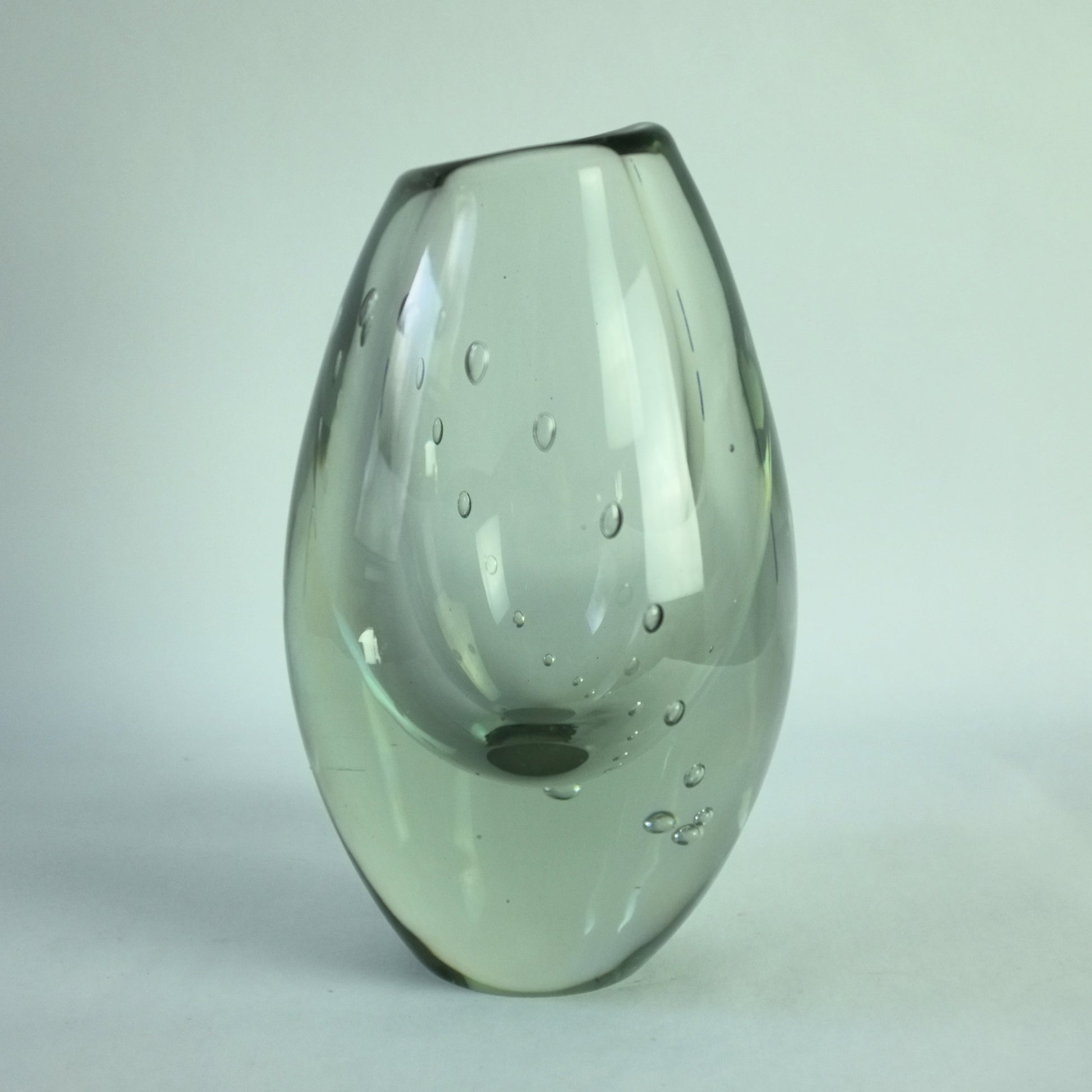 A clear glass vase with an internal line of air bubbles depicting a pearl necklace.