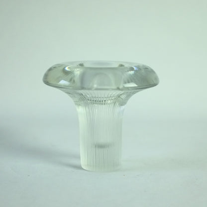 A clear glass vase with vertical lines engraved from the base to the rim, displaying a distinctive shape of a mushroom.